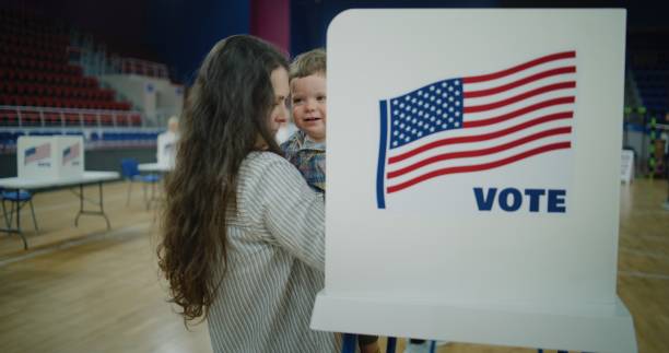 istock Woman with child on hands comes to voting booth 2150384760