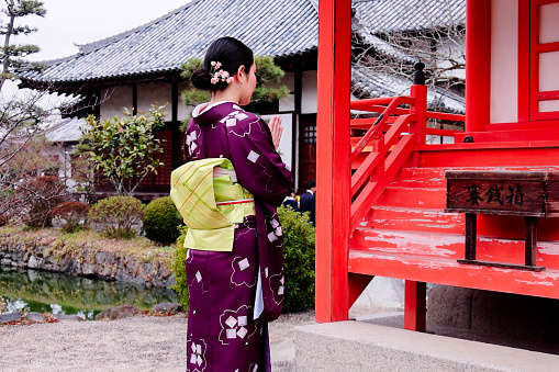 A foreign tourist and Japanese woman  visiting the shrine grounds wearing kimonos