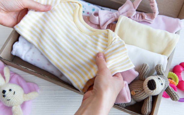 istock Women's hands collect children's clothes into boxes. 2150386216