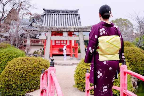 A foreign tourist and Japanese woman  visiting the shrine grounds wearing kimonos