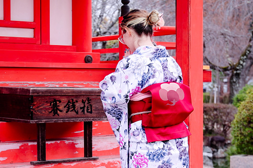 A foreign tourist and Japanese woman  visiting the shrine grounds wearing kimonos