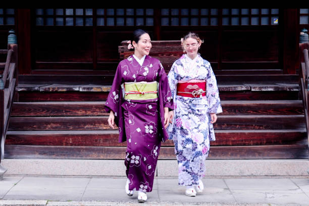 A foreign tourist and Japanese woman  visiting the shrine grounds wearing kimonos
