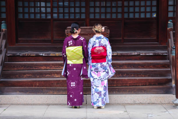 A foreign tourist and Japanese woman  visiting the shrine grounds wearing kimonos