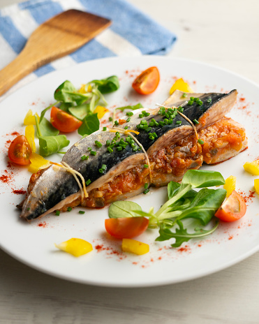 Oven-cooked mackerel stuffed with tomato sauce and vegetables..