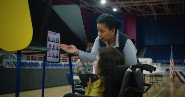 istock Female US voter with SMA uses remote buttons and votes on tablet 2150386766
