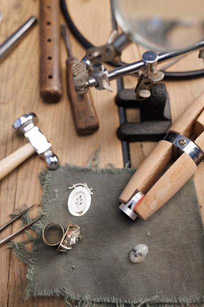 istock Jeweler craft  workshop  produces hand made  a ring    jeweler tools on rustic wooden table 2150389366