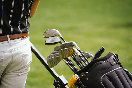 Close up of golfer pulling his golf bag