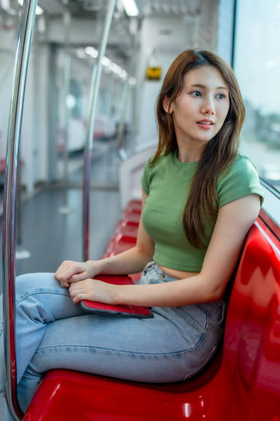 istock Young Woman Seated with Tablet on Subway Train 2150392437