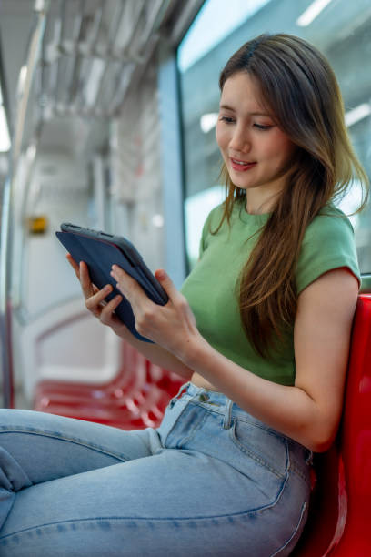 istock Smiling Woman Reading on Tablet in Metro Train. 2150392439