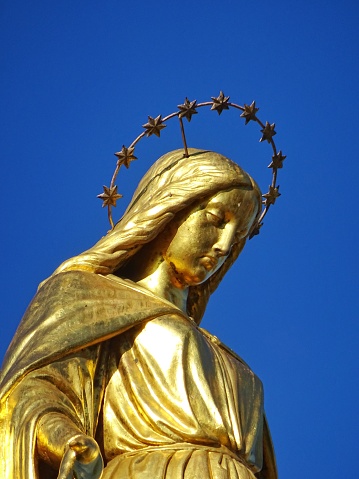 A close up picture of a golden statue of Virgin Mary