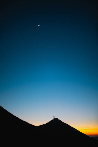 Lighthouse on the peak of the mountain at sunset