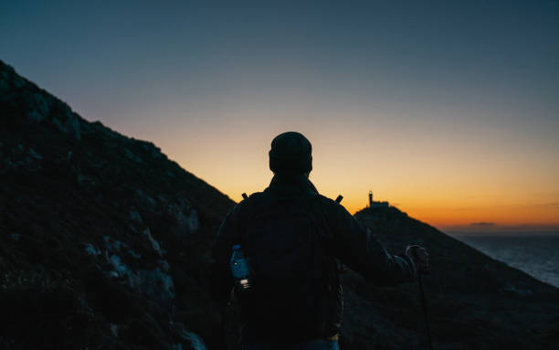 istock Tourist hiking in mountains at sunset 2150394040