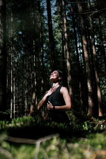A young woman does yoga and meditates in the forest. Yoga and meditation concept. Yoga asanas.