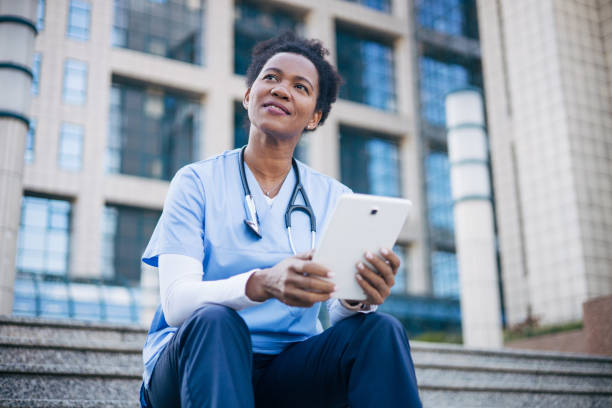 istock African female doctor using digital tablet outdoors. 2150394491