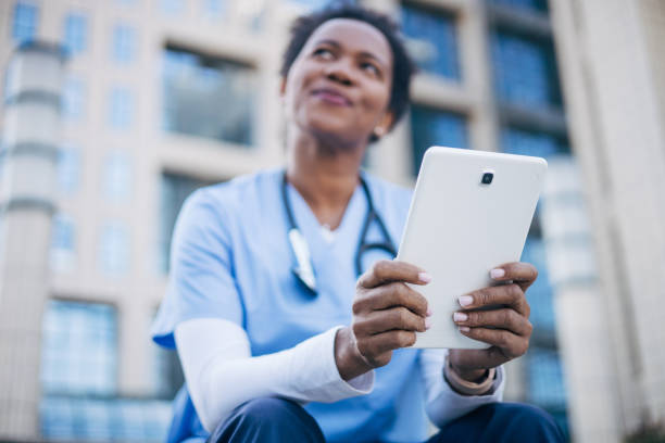 istock African female doctor using digital tablet outdoors. 2150394601