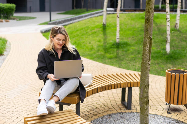 istock Young woman with laptop outside 2150395624