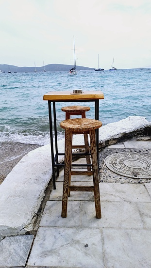 Wooden table and chairs by the sea.  seascape
