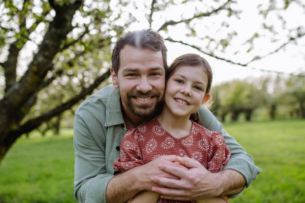 istock Father hugging his daughter in spring nature. Father's day concept. 2150396324
