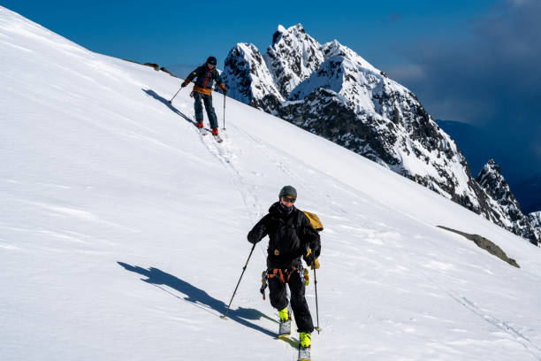 istock Backcountry skiers climb mountain 2150396419