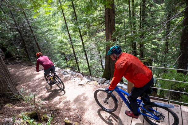 istock Senior men ride across bridge in forest 2150397338