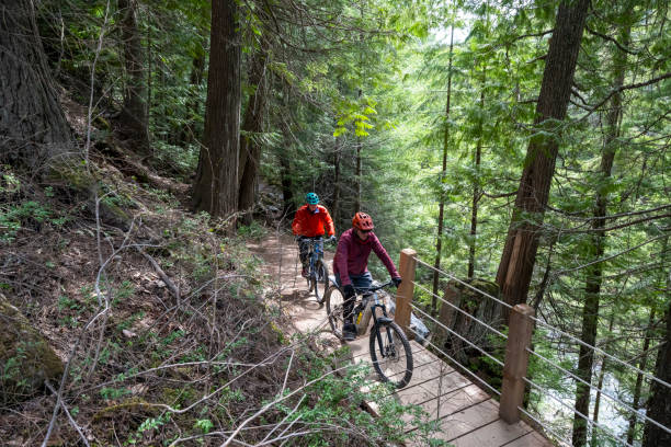 istock Senior men ride across bridge in forest 2150397934