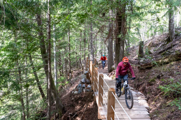 istock Senior men ride across bridge in forest 2150397936