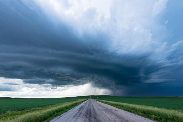 istock Dramatic Dark Storm Clouds Over A Peaceful Country Road 2150399448