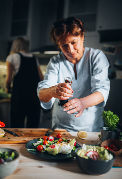 Close-up of a woman spicing up the dish