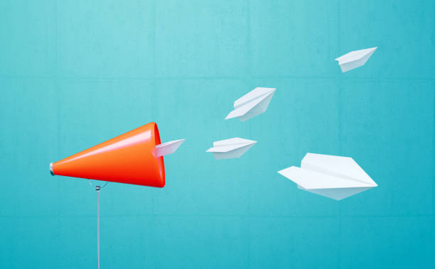 istock White Paper Planes Flying Away From A Coral Colored Megaphone Before Blue Background 2150402278