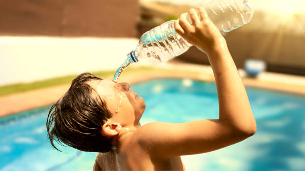 istock Boy drinking a bottle of water on a hot summer day 2150402765