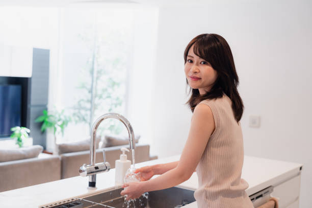 istock Young woman washing dishes in the kitchen 2150405937