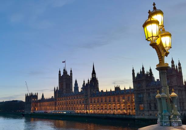 fotografii de stoc, fotografii și imagini scutite de redevențe cu palatul parlamentului din westminster, londra, la amurg, cu o lampă istorică pe podul westminster în prim-plan. - clădire istorică