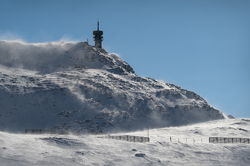 A tower on the mountain in a sunny and windy day during the winter