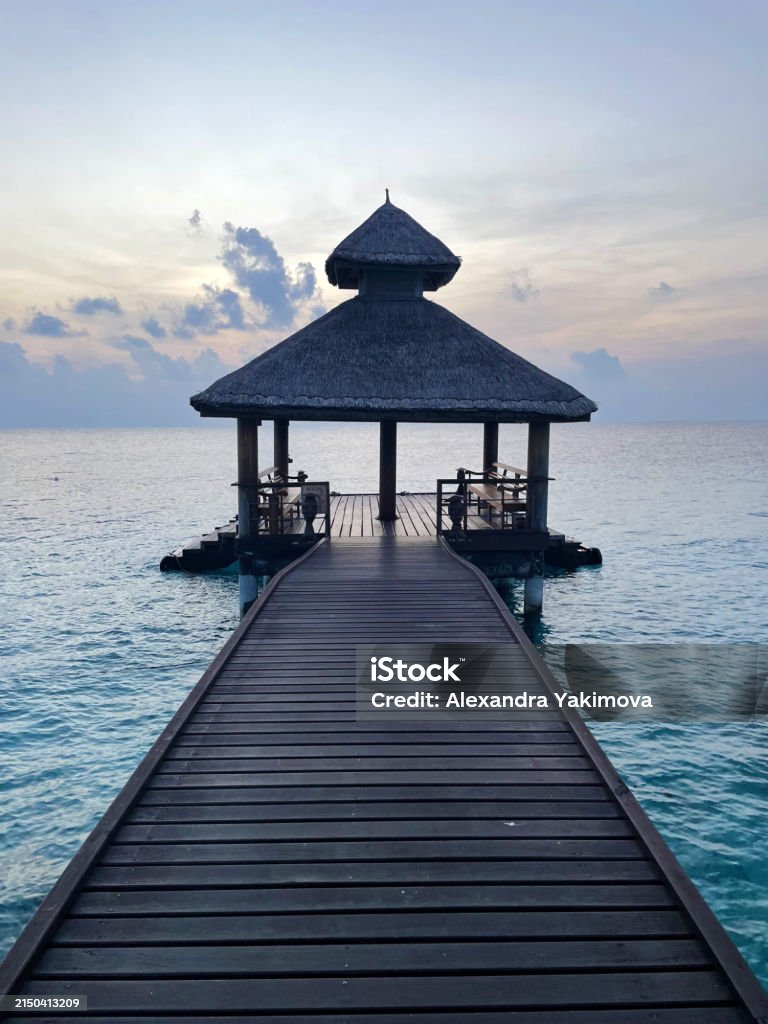 Molo del resort maldiviano all'alba o al tramonto, foto verticale - Foto stock royalty-free di Isole Maldive Molo del resort maldiviano all'alba o al tramonto, foto verticale - Foto stock royalty-free di Isole Maldive