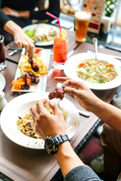 istock Group of People Sitting Around a Table Eating Food 2150413752