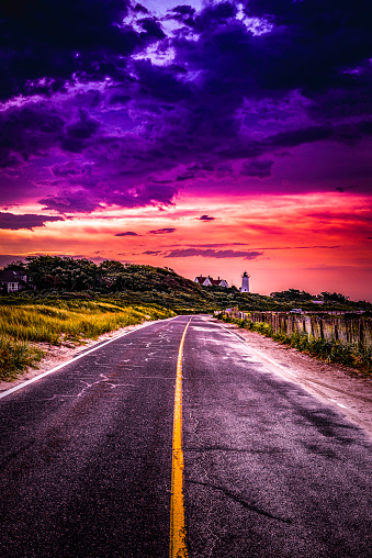Saturated vibrant ethereal sunset with purple and red cloudscape over the coastal road on Cape Cod, Massachusetts, USA