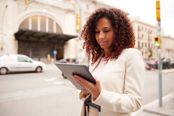 istock Urban Commute: Businesswoman Using Digital Tablet on Downtown Street 2150418595