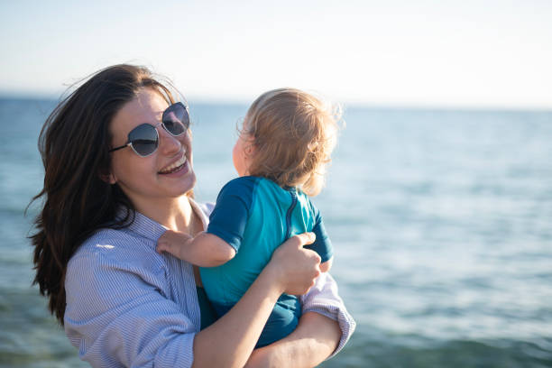 Portrait of happy mother and little son at the beach.
