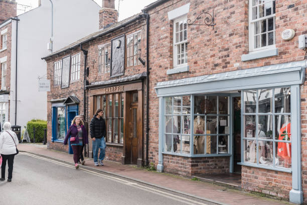 Nantwich, Cheshire, England. April 20th 2024. People walk past traditional brick storefronts on the high street.