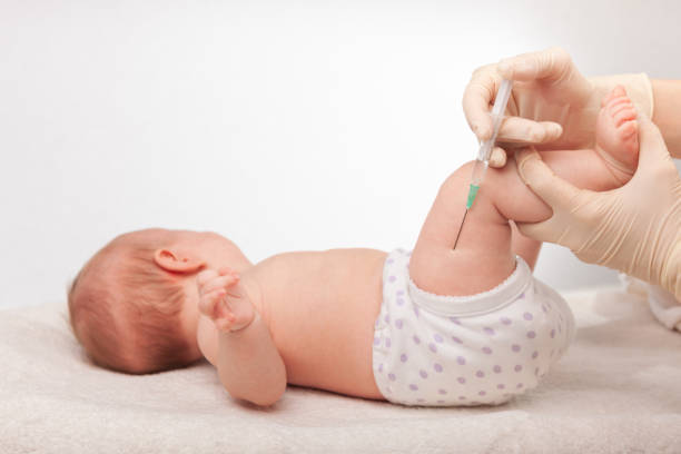 Baby Vaccination Day Baby receives a vaccination from a healthcare professional. Gloved ands shown carefully holding the syringe and the child's leg to ensure safe and precise injection hand thigh stock pictures, royalty-free photos & images