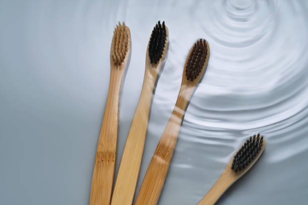 istock Natural bamboo toothbrushes in water on a blue background. 2150427259