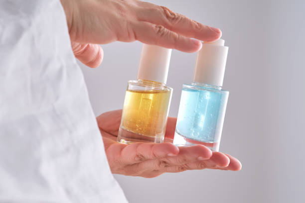 istock Two yellow and blue serums in a womans hands in a robe. 2150429236