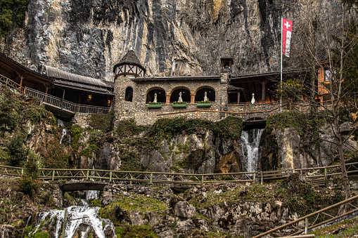 Swiss Building by waterfall on side of the Mountain in Switzerland