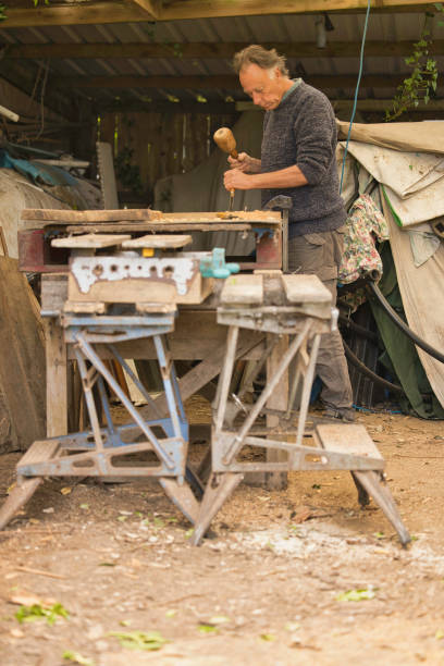 Craftsman working in his very untidy workshop.