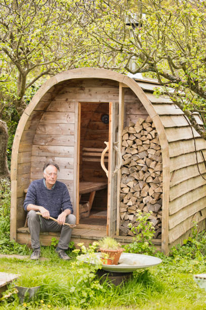 istock Senior man sitting outside his homemade sauna 2150438184