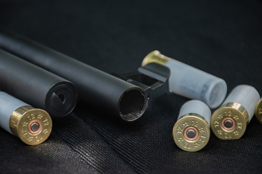 Shotgun, shotgun cartridges on a black leather background, soft and selective focus