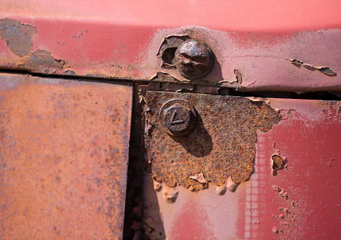 Old rusted bolt on red truck