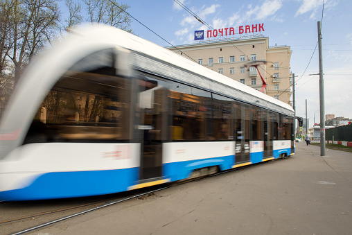 Moscow, Russia - 04.21.2024. Russian tramway in quick motion in the suburbs near metro Voykovskaya, Leningradskij prospect. Building of post office in background
