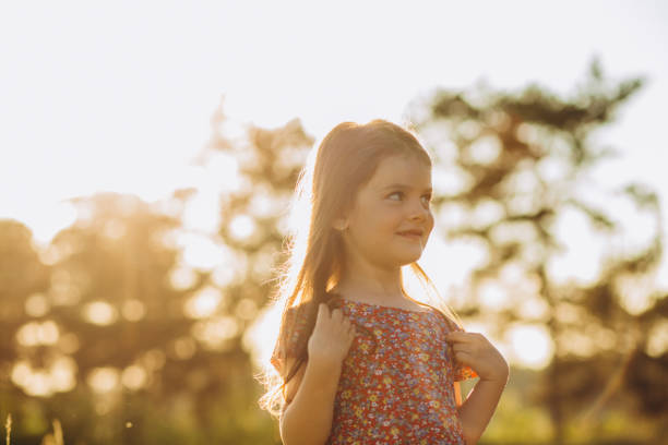 Little girl running on meadow with sunset