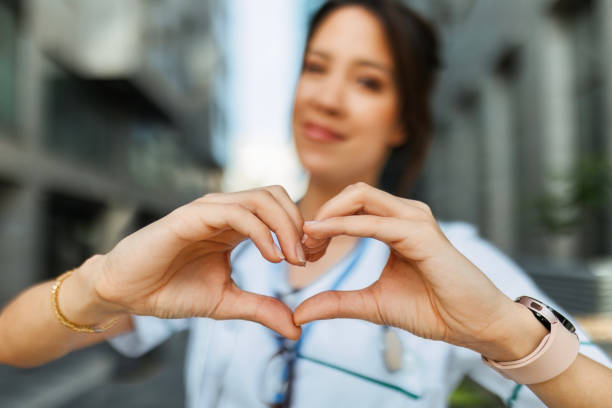 istock Young Nurse Woman in Uniform Forming Heart Shape with Hands 2150448380